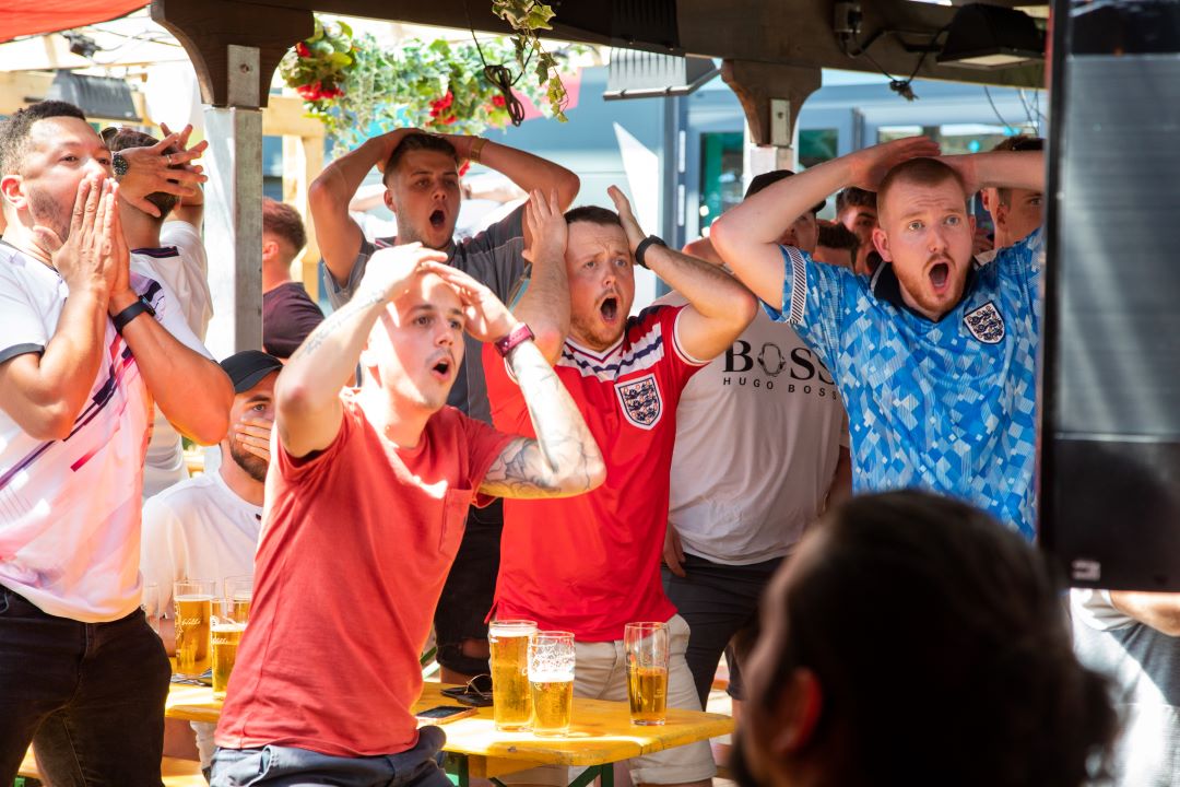 group of people watching live sports at a pub