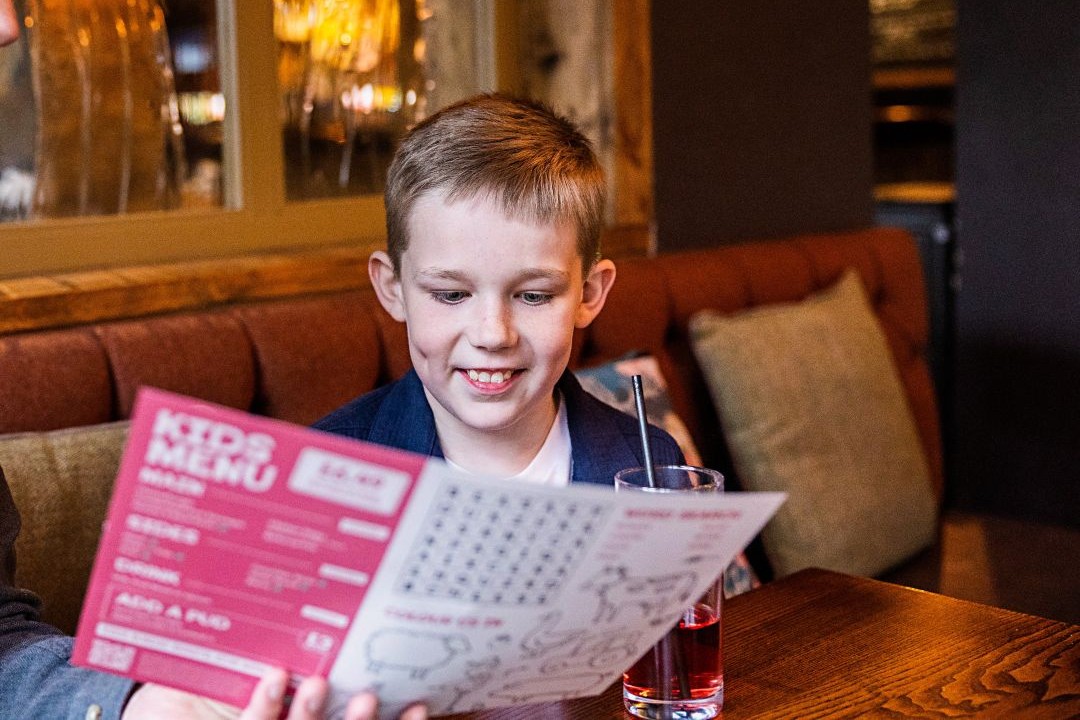 A child choosing from a kids menu in a pub
